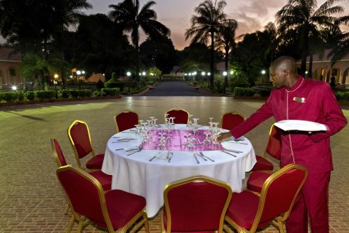 a man standing in front of a table with wine glasses at Dunia Hôtel Bissau in Bissau