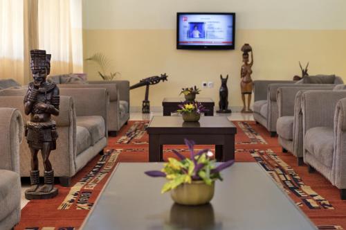 sala de estar con muebles y TV de pantalla plana. en Dunia Hôtel Bissau en Bissau