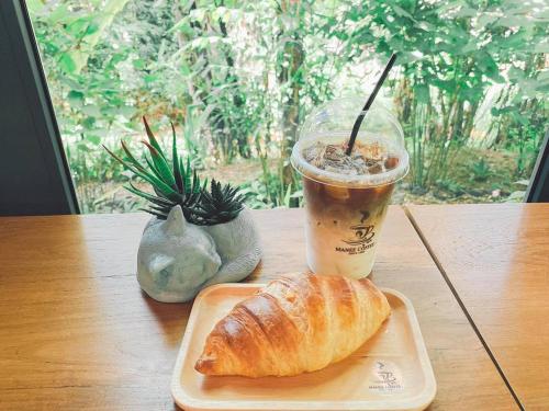 a pastry and a cup of coffee on a table at Bangnu Greenery Resort in Takua Thung