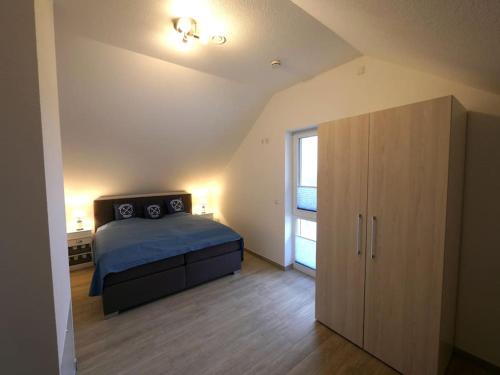 a bedroom with a blue bed and a cabinet at Villa Heimathafen in Trent