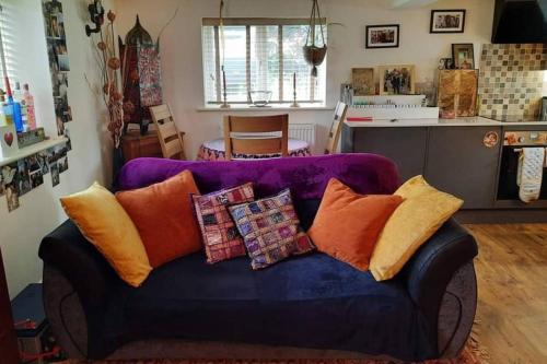 a living room with a purple couch with pillows at Cosy cottage in picturesque Hawkshead in Hawkshead