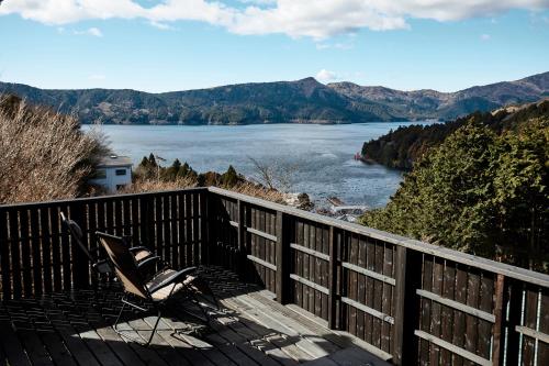two chairs on a deck with a view of a lake at Villa Noël HAKONE FUJI Sauna&Open Air Bath in Hakone