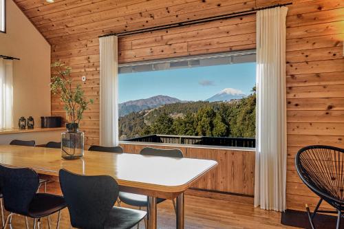 a dining room with a table and a large window at Villa Noël Hakone Fuji Sauna&Open Air Bath in Hakone