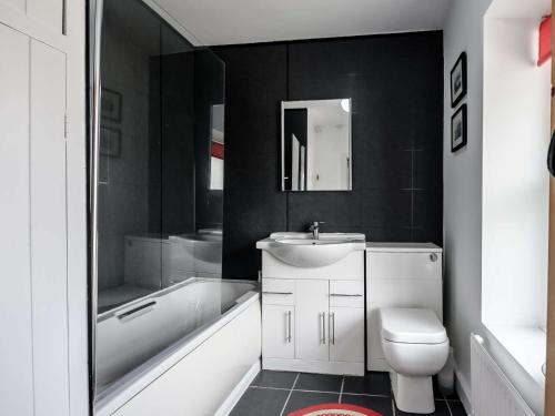 a bathroom with a sink and a toilet and a bath tub at 2 Bed in Aberdovey 80399 in Llwyngwril