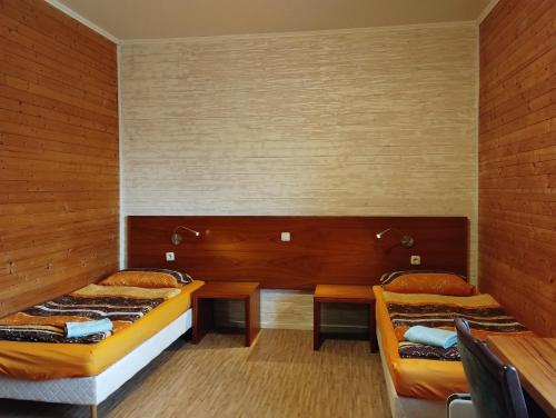 two beds in a room with wooden walls at Apartmán v dřevěném domě in Františkovy Lázně
