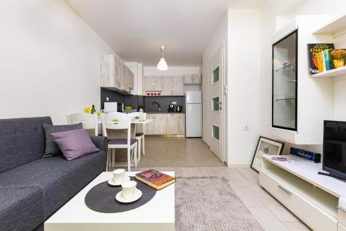a living room with a couch and a table at Radiant Retreat: Bright 1BD Haven in Plovdiv in Plovdiv