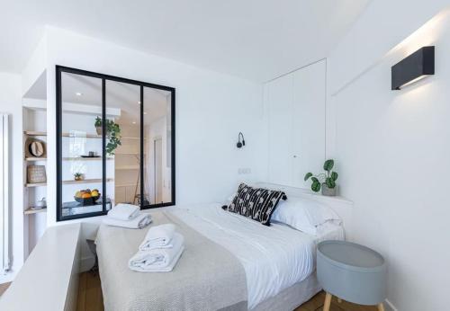 1 dormitorio blanco con 1 cama grande y espejo en MY CASA - PILATTE - BLUE - Beautiful studio on Seafront, en Niza