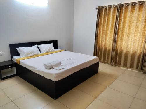 a bed with white sheets and towels on it in a room at Private Room in villa in Bāgalūr