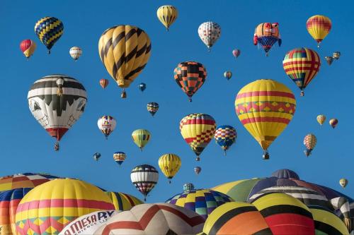 a bunch of hot air balloons in the sky at Cottonwoods 1-D in Aspen