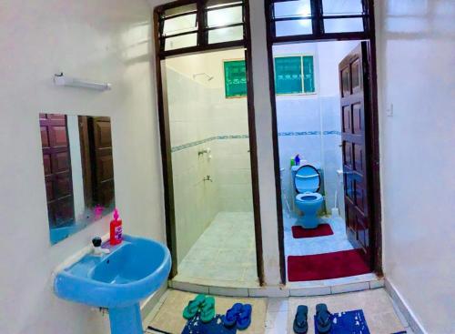 ein Badezimmer mit einem blauen WC und einem Waschbecken in der Unterkunft D15 in Mombasa