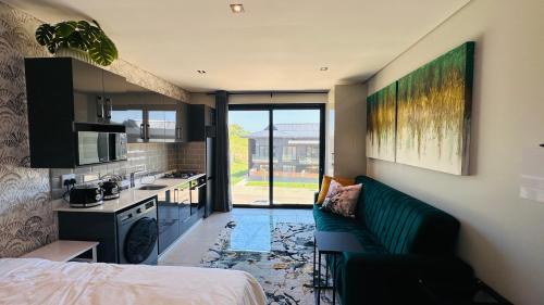 a living room with a couch and a kitchen at Zimbali Ocean Club Ballito Apartments in Ballito