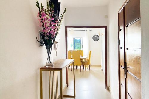 a hallway with a table with a vase of flowers on it at Residence Atlantic - Premium Apartment - WiFi, Gardien, Parking, Climaté in Douala