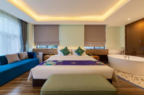 a bedroom with a bed and a bathtub and a bed and couch at Overseas Chinese Town Nanyang Inn in Shenzhen