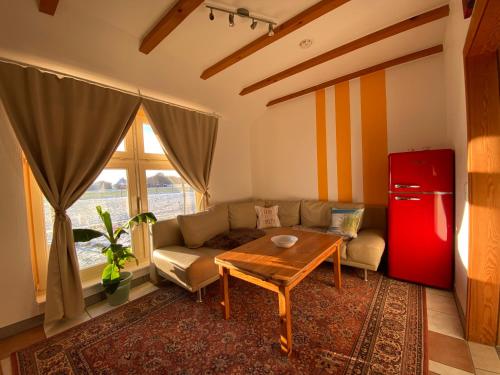 a living room with a couch and a table and a red refrigerator at Ferienhaus Banana Lodge in Bruchhausen-Vilsen