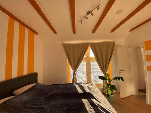 a bedroom with a bed and a large window at Ferienhaus Banana Lodge in Bruchhausen-Vilsen