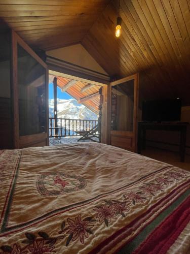 a bedroom with a bed with a view of a mountain at Les Chalets du Villard in Saint-Véran