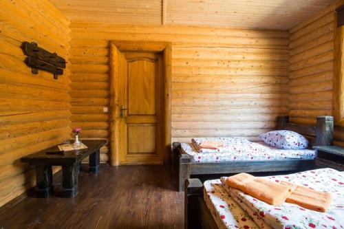a room with two beds in a log cabin at Кремениця in Rivna