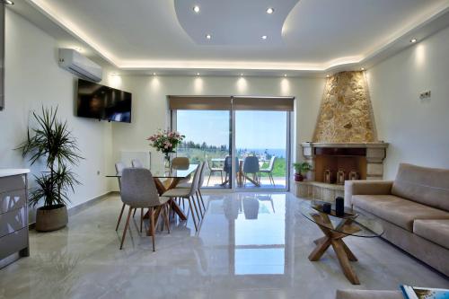 Goudis Villas في تسوكالادهيز: غرفة معيشة مع أريكة وطاولة