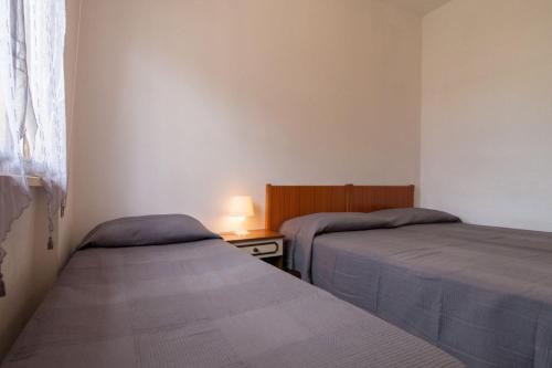 um quarto com 2 camas e uma mesa com um candeeiro em Appartamento GIGLIO em Follonica
