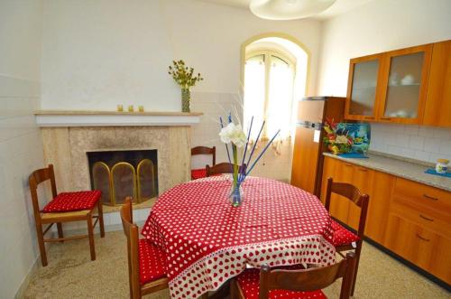 een eetkamer met een tafel en een open haard bij GINESTRA 3 in Marina di Pescoluse