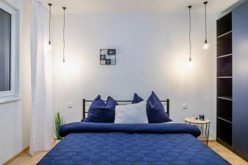 1 dormitorio con cama azul y almohadas azules en Jana's WoW apt, 2BR, Metro next door, near the airport, en Praga