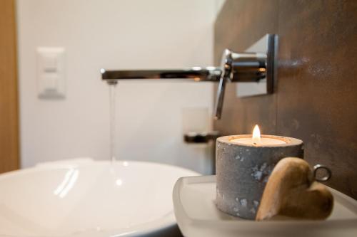 a candle sitting on top of a sink in a bathroom at Alpenresort B22 in Riederalp