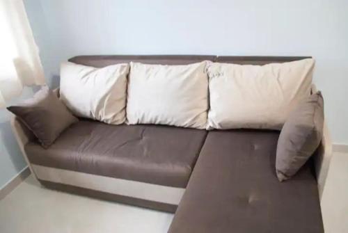 - un canapé en cuir brun avec trois oreillers dans l'établissement Kostas Cozy Charming Appartment, à Thessalonique