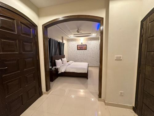a bedroom with a bed and a door with a mirror at Sunrise Residence in Islamabad