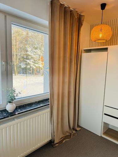 a window with curtains in a room at Villa Vincentów in Myślenice