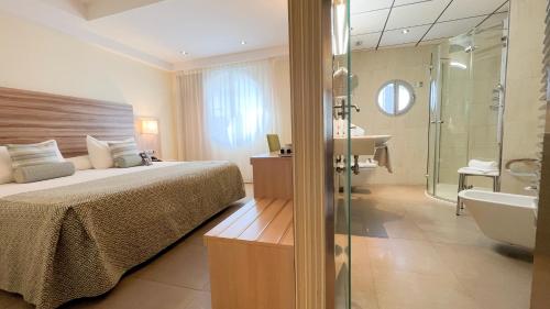 1 dormitorio con cama, ducha y lavamanos en Riviera Beachotel - Adults Recommended en Benidorm