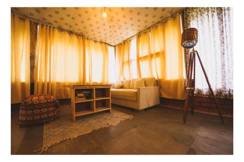a living room with yellow curtains and a couch at Aranya by Stories in Jaipur