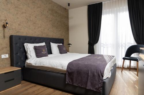 Vetus Hotel في بريشتيني: غرفة نوم بسرير كبير ونافذة