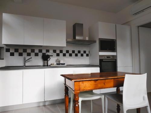 a kitchen with a wooden table and white cabinets at MonteRoom-Apartments in Bologna