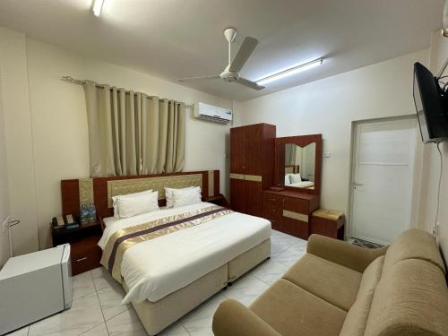 a hotel room with a bed and a couch at Bahla Jewel Hotel Apartments in Bahlāʼ