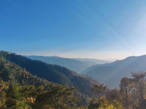 a view of a valley in the mountains at Green Lodge Farmstay by Highland Monk in Shimla