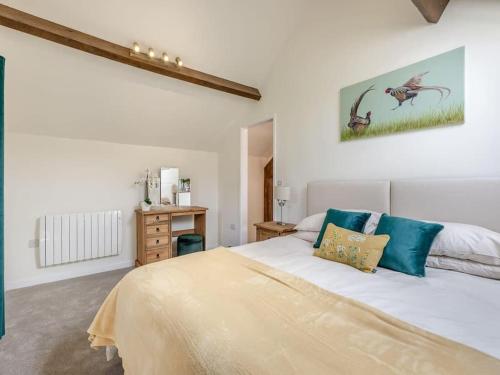 a bedroom with a large white bed with blue pillows at The Barrels at Leintwardine in Leintwardine