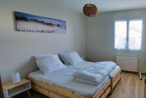 a bedroom with a bed with white sheets and pillows at Maison neuve 6/8p à La Cotinière in La Cotinière