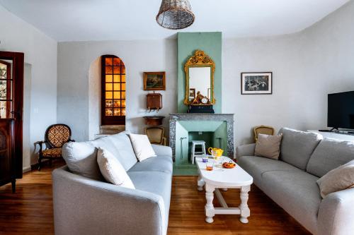 a living room with two couches and a fireplace at La Closerie D'Escalin in La Garde-Adhémar