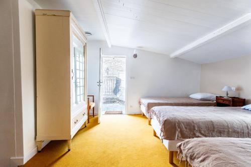 a room with two beds and a window at La Closerie D'Escalin gîte 12 personnes et Jacuzzi in La Garde-Adhémar