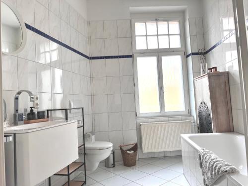 a bathroom with a tub and a toilet and a sink at Großzügiges Familien Apartment am Kressepark in Erfurt