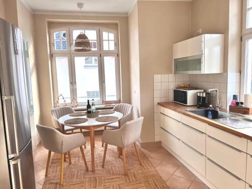 a kitchen with a table and chairs in a kitchen at Großzügiges Familien Apartment am Kressepark in Erfurt