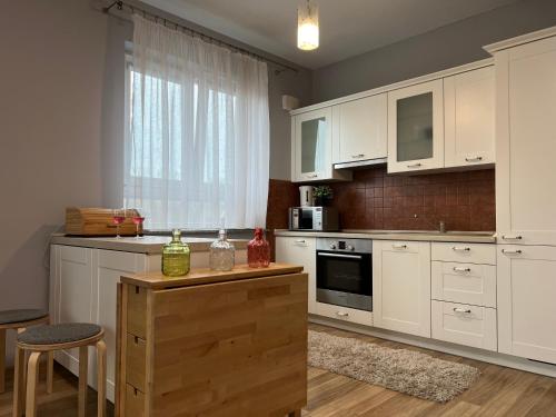 a kitchen with white cabinets and a table and a window at Parkcity Park Śląski in Katowice