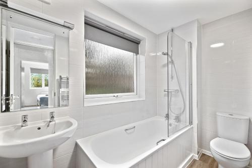 a white bathroom with a sink and a toilet at 20% OFF Spacious Cosy Home with Free Parking in Exeter