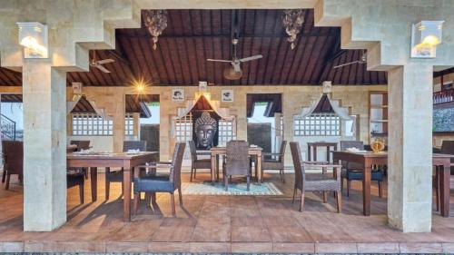 a dining room with wooden tables and chairs at Anda Amed Villas & Spa in Amed