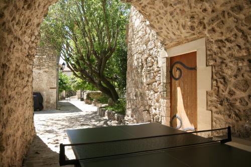 a stone wall with a bench in front of a door at La Closerie D'Escalin gîte 12 personnes et Jacuzzi in La Garde-Adhémar
