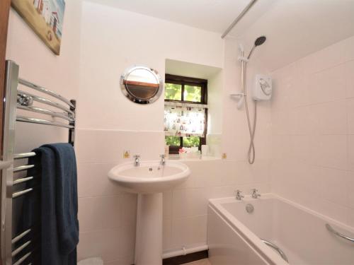 a white bathroom with a sink and a tub and a shower at 3 Bed in Okehampton TCOAH in Broadwoodwidger