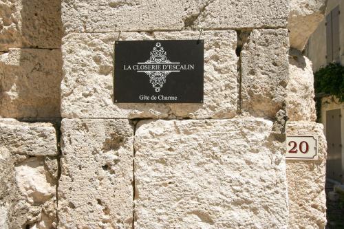 a sign on the side of a stone wall at La Closerie D'Escalin gîte 12 personnes et Jacuzzi in La Garde-Adhémar