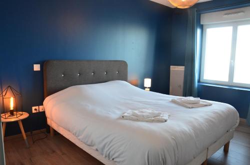 - une chambre bleue avec un lit et 2 serviettes dans l'établissement Digue, à Wimereux