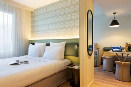 una camera d'albergo con letto e scrivania di Citadines Les Halles Paris a Parigi