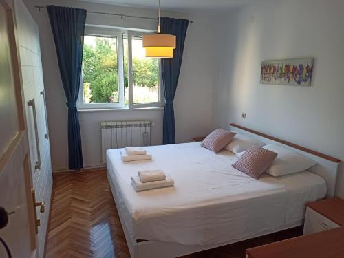 una camera da letto con un letto bianco e asciugamani di Tonka Apartment a Trogir